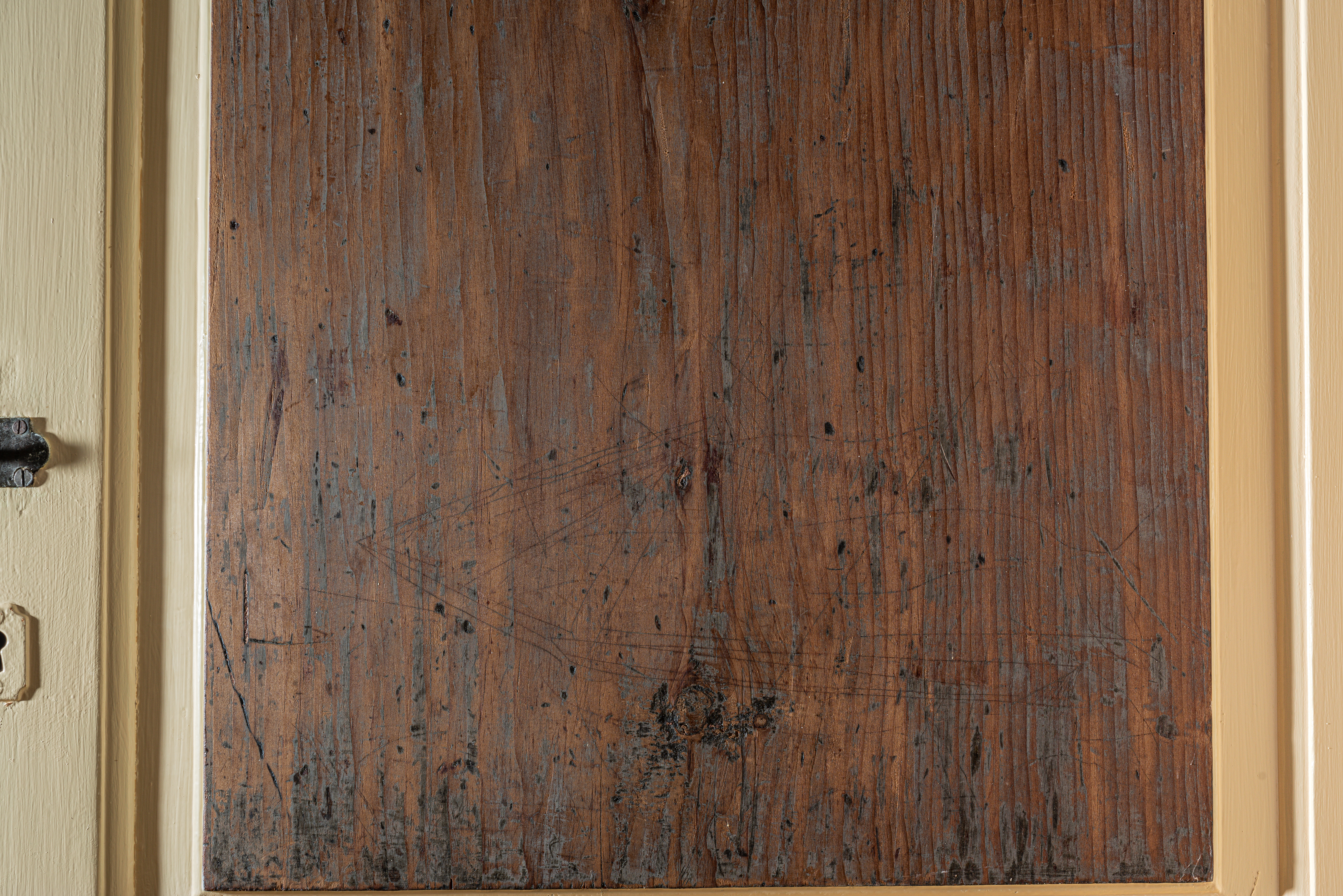primitive line drawing of a Clipper ship etched into a wooden door panel
