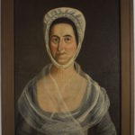 Half-length portrait of a middle-aged white woman with a white bonnet over dark hair, a blue-gray dress, and a translucent white shawl.