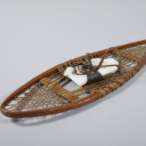 A single wooden snowshoe with animal sinew lacing and dark brown leather shoe lacing.